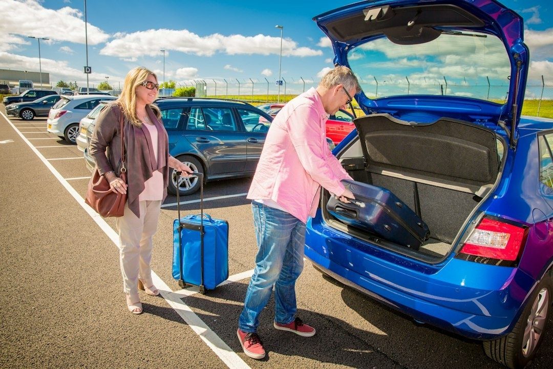 Par legger en sammenlagt barnevogn i et ryddig bagasjerom