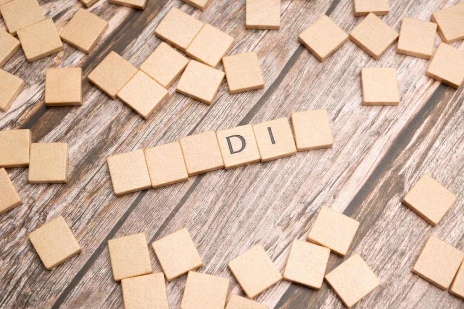 Trefliser spredt på et bord med bokstavene D og I synlig.